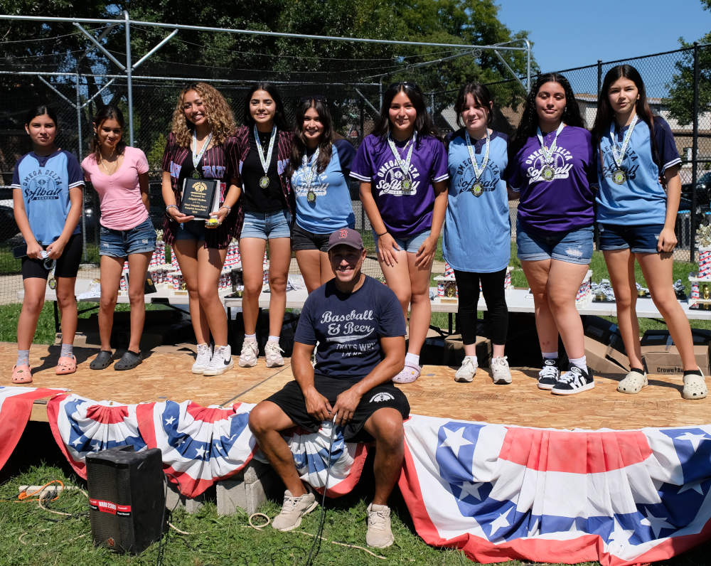 Coach and league head Danny Gaichas and players of the Screwballs girls softball team celebrate the season at the Omega Delta Youth Baseball and Softball League awards ceremony on Saturday, August 31, 2024, at Hoyne Park, 3431 S. Hamilton Ave., Chicago.