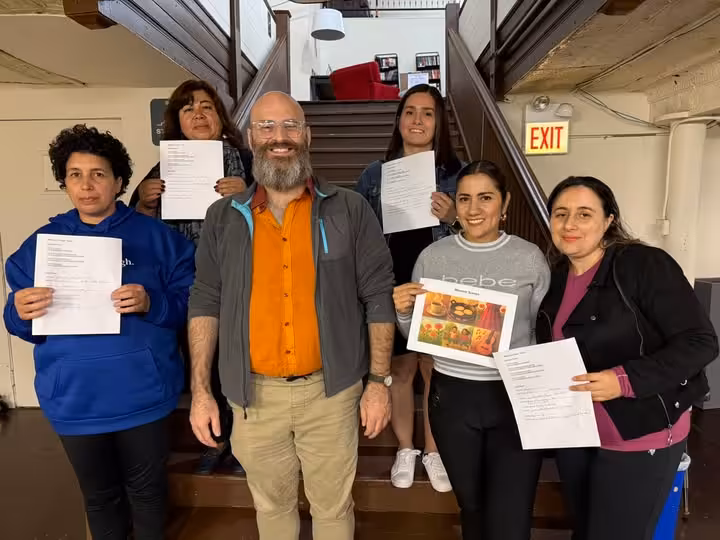 Dr. Patrick Santoro and Resilient Roots students show off their storytelling work at Aquinas Literacy Center.