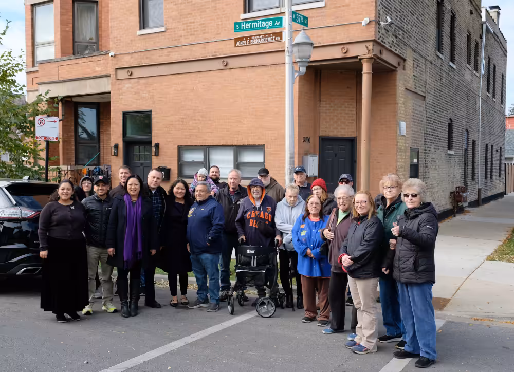 Community members and family gather on November 1, 2025, at West 37th Street and South Hermitage Avenue for the street sign unveiling.