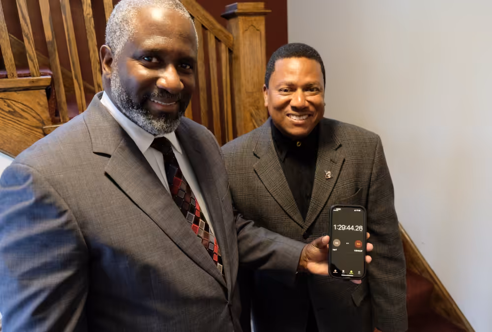 Pastor Eduardo Mack, left, and church associate Elvis Núñez check the event timer after the start of the Bible reading marathon at South Shore Hispanic Seventh-day Adventist Church.