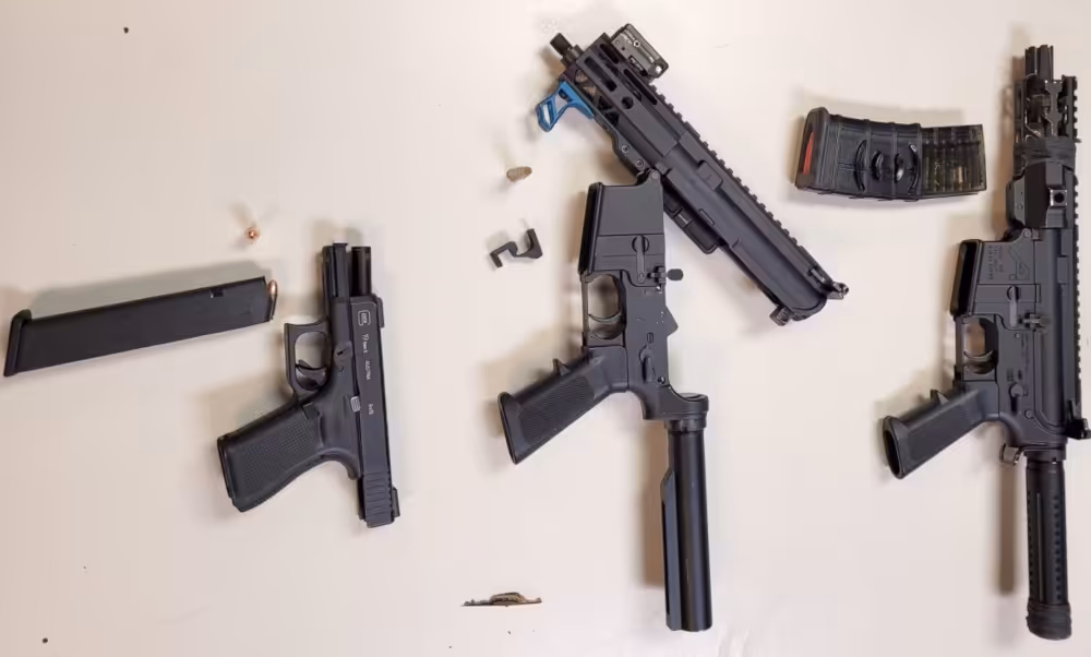 Three guns recovered from the February 23, 2026, arrests are dismantled and on display by the Chicago Police Department.