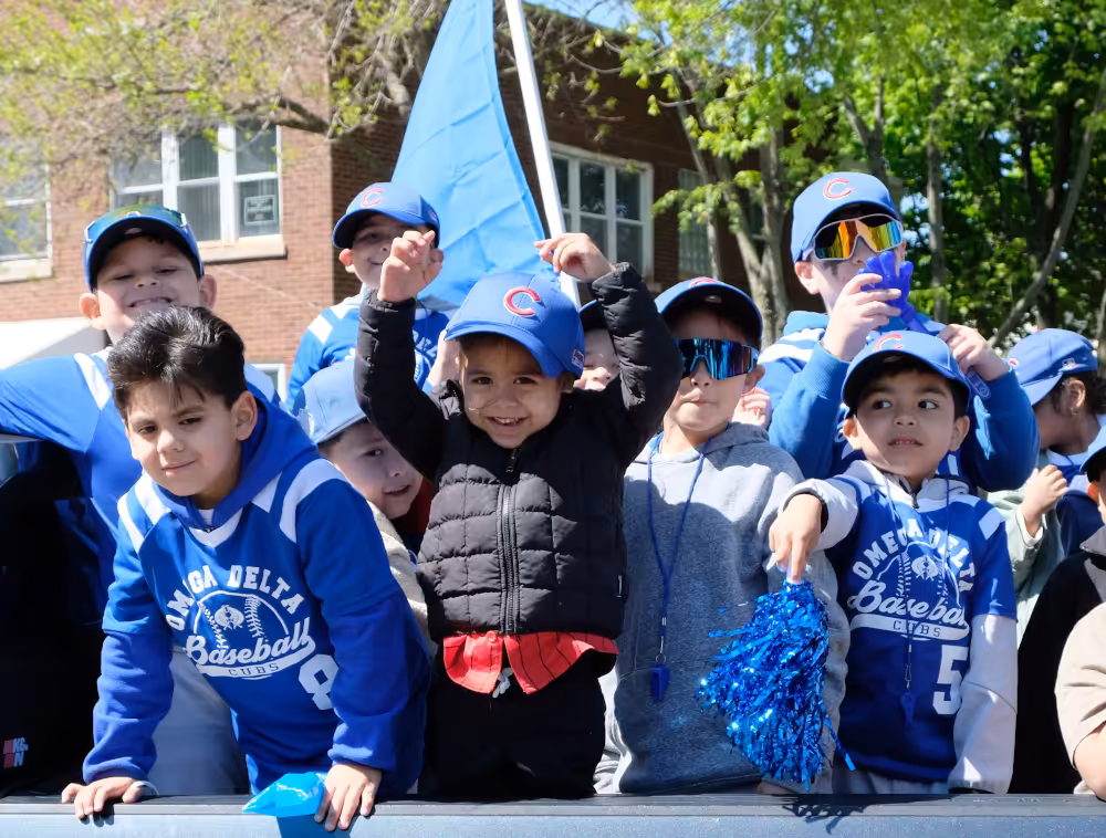 Members of the kids Cubs team unloads at the end of the parade through the McKinley Park neighborhood at Omega Delta Youth Baseball & Softball League's opening day on Saturday, April 25, 2026.